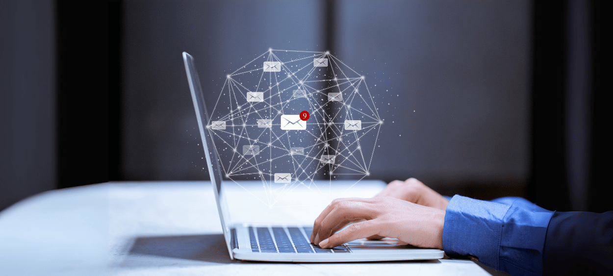 email-marketing - aitomdigital.com Na obrázku je notebook ze strany, nad ním levituje emailingová síť