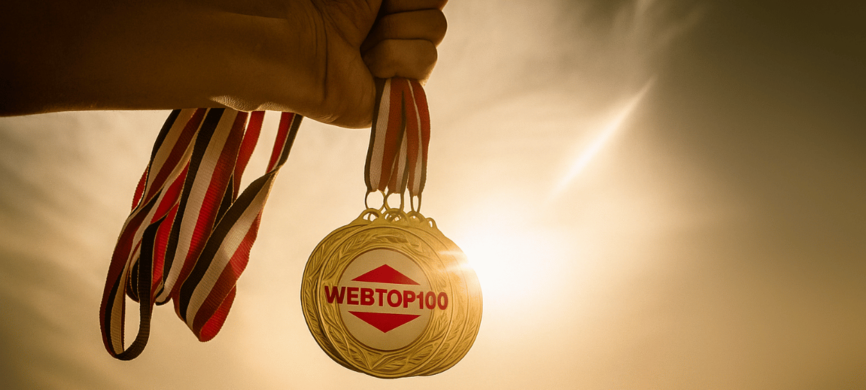medaile-webtop100 - aitomdigital.com Na obrázku je ruka držící medaile na kterých je logo webtop100